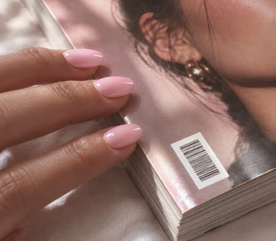 Fingertips on the glossy cover of a printed magazine