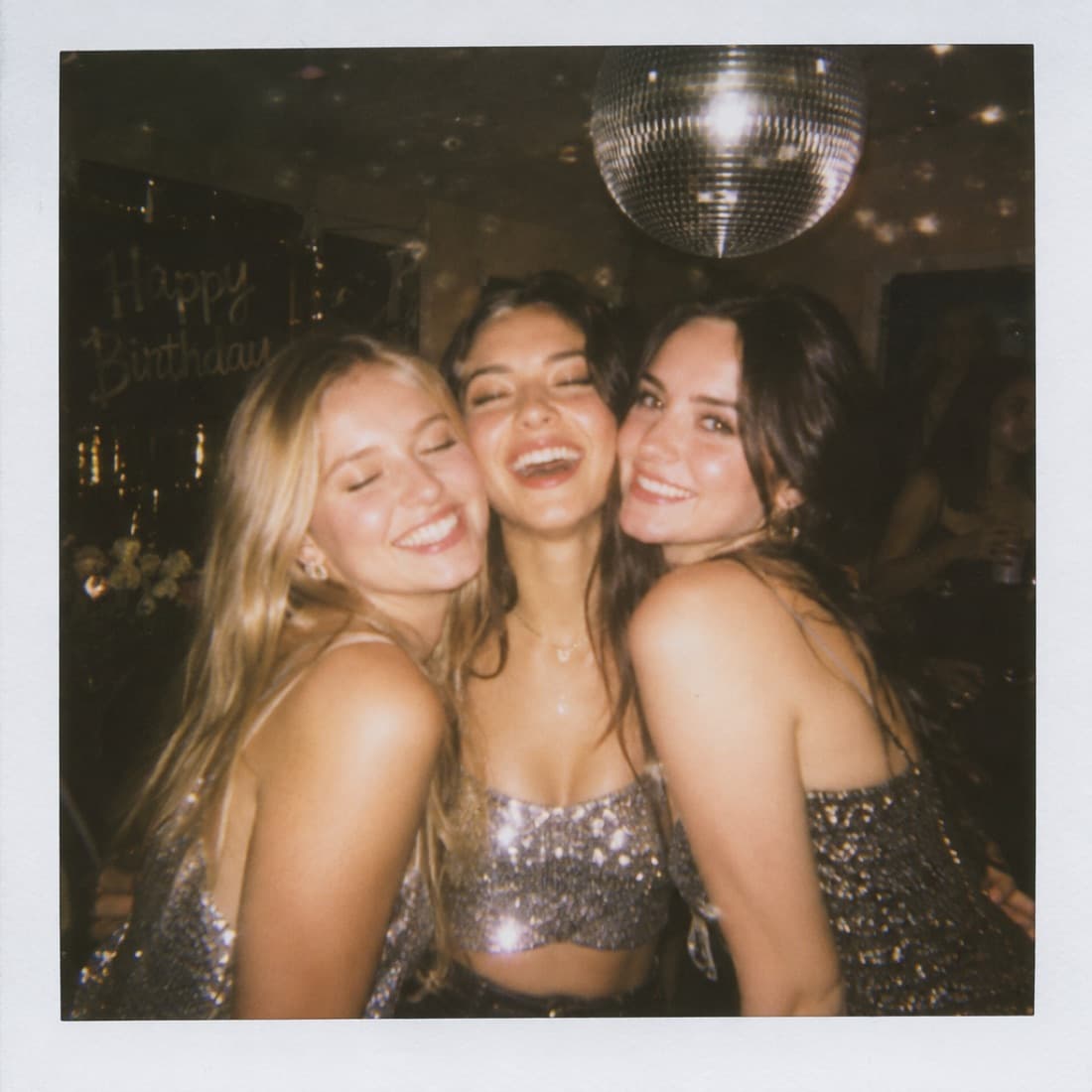 The girls hugging under a disco ball